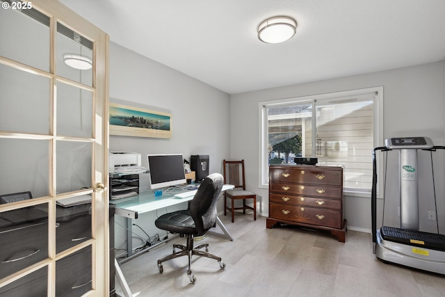 home office with light wood-style floors and baseboards