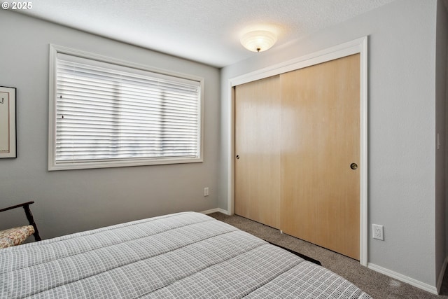 bedroom featuring a closet, baseboards, and carpet floors