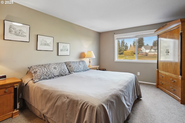bedroom with baseboards and light colored carpet