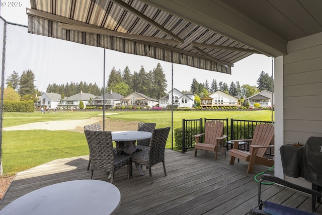 deck with a yard, outdoor dining space, and a residential view