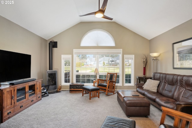 carpeted living area featuring ceiling fan, lofted ceiling, and a wood stove