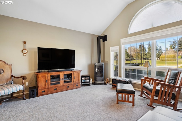 living area with a wood stove, high vaulted ceiling, and carpet