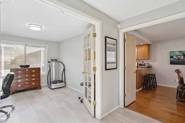 office area with baseboards and light wood-type flooring