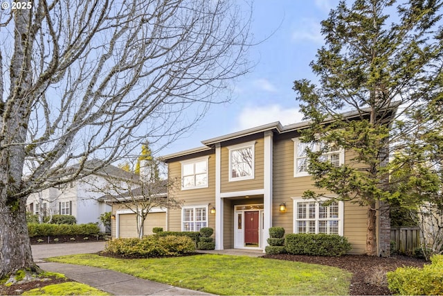 view of front of home with driveway, a front lawn, an attached garage, and fence