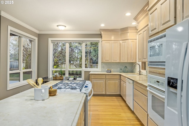 kitchen with white appliances, a sink, ornamental molding, decorative backsplash, and light brown cabinetry