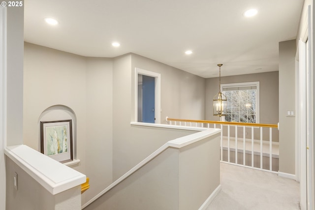 hallway with a notable chandelier, recessed lighting, light carpet, an upstairs landing, and baseboards