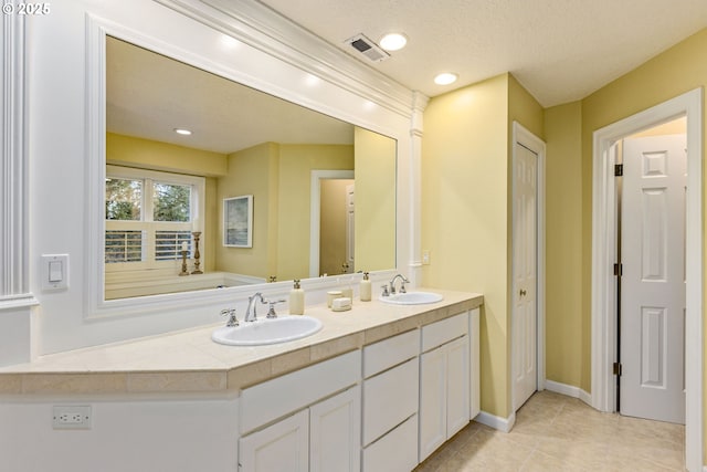 bathroom with double vanity, tile patterned flooring, a sink, and visible vents