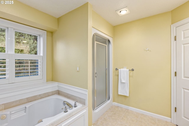 bathroom featuring a shower stall, baseboards, a bath, and tile patterned floors