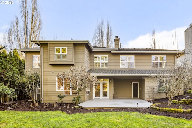 back of property with a patio, a yard, and a chimney