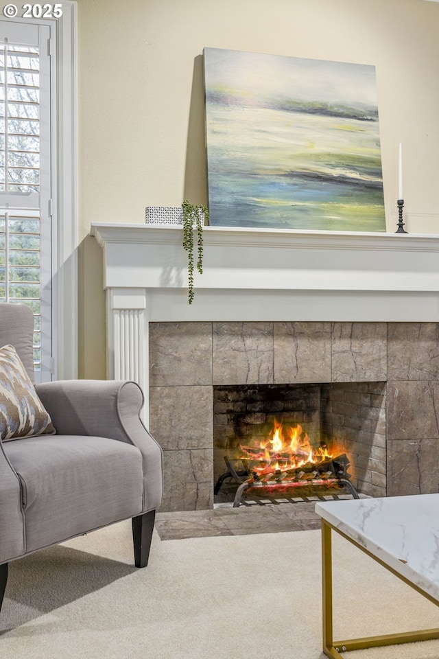 sitting room featuring carpet floors, a tiled fireplace, and a wealth of natural light