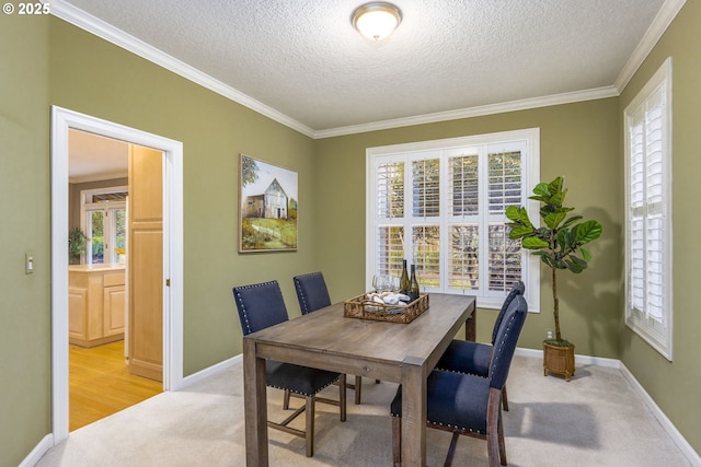 dining room featuring ornamental molding, light carpet, and baseboards