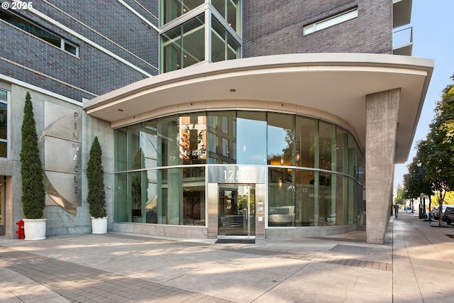 view of exterior entry featuring brick siding