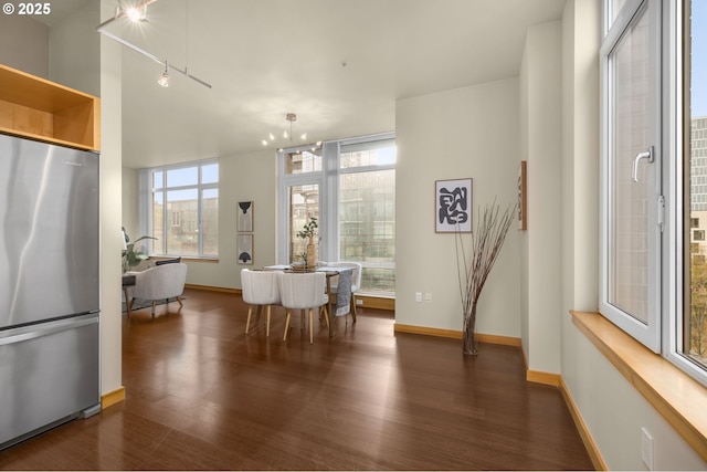 dining space featuring dark wood-style flooring and baseboards