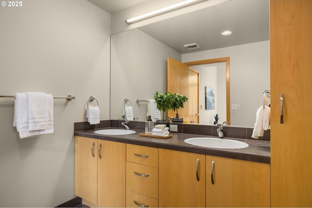 bathroom featuring visible vents, a sink, and double vanity