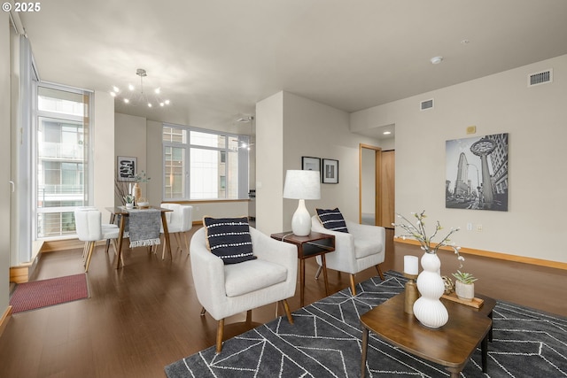 living area with dark wood-type flooring, visible vents, and baseboards