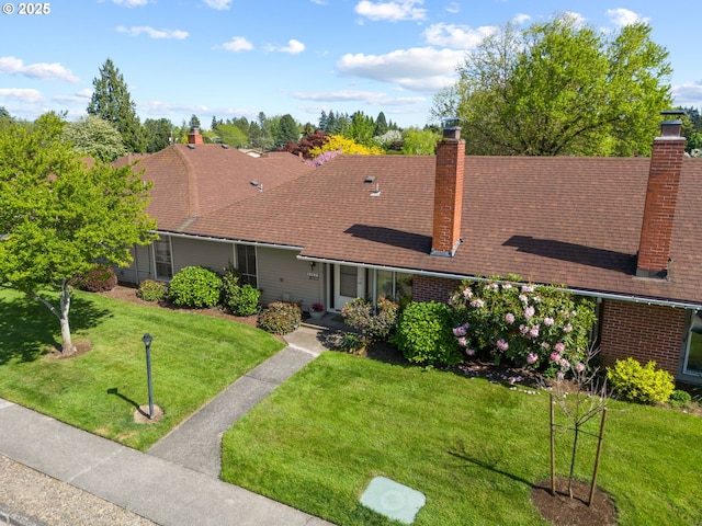 view of front facade featuring a chimney and a front lawn
