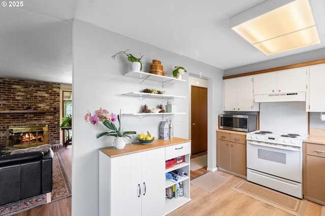 kitchen featuring open shelves, stainless steel microwave, under cabinet range hood, and electric range