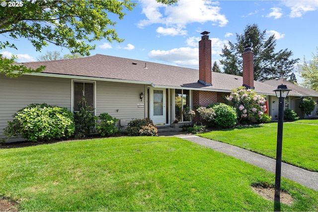 ranch-style house featuring a chimney and a front yard