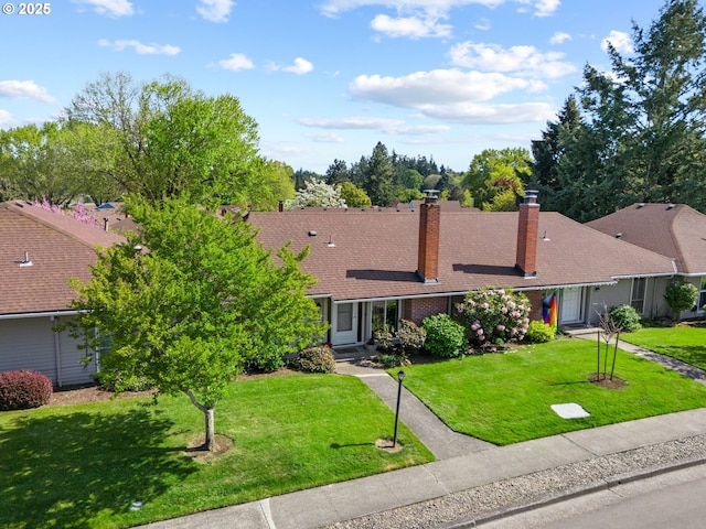 view of front of property with brick siding, a chimney, and a front lawn