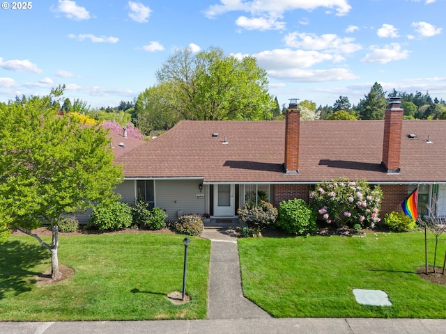 single story home with a chimney, brick siding, and a front yard