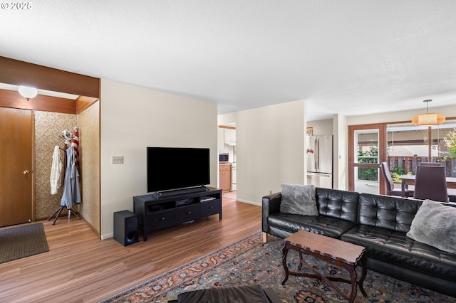 living area with baseboards and wood finished floors