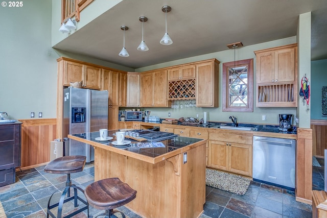 3360 NW Oceanview Dr, Newport, OR 97365 - kitchen with appliances with stainless steel finishes, stone tile floors, a sink, a wainscoted wall, and a center island