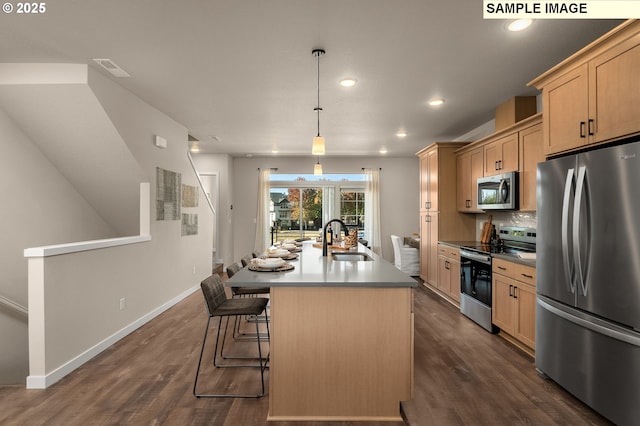 3522 SE Brookwood Ave, Hillsboro, OR 97123 - kitchen with stainless steel appliances, a sink, a kitchen island with sink, light brown cabinets, and dark wood finished floors