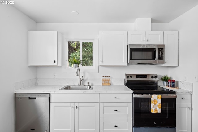 3235 SE 69th Ave, Portland, OR 97206 - kitchen featuring stainless steel appliances, white cabinets, and light stone counters
