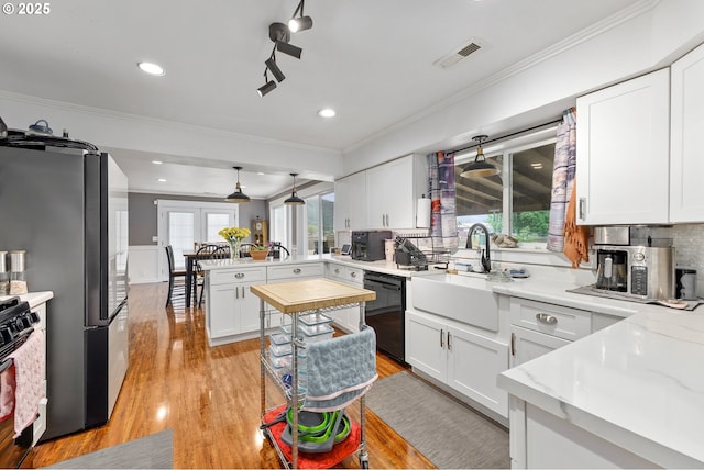 190 Walnut St, Myrtle Creek, OR 97457 - kitchen with black dishwasher, a peninsula, crown molding, a sink, and light wood-style flooring