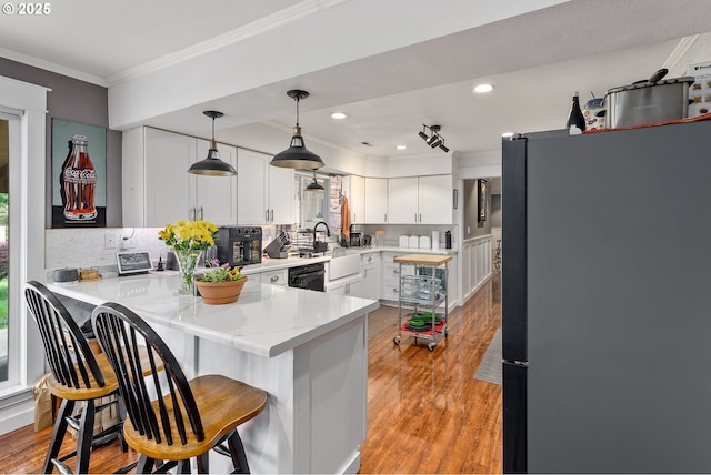 190 Walnut St, Myrtle Creek, OR 97457 - kitchen featuring freestanding refrigerator, ornamental molding, white cabinets, dishwashing machine, and light countertops