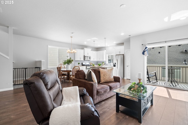 living room featuring dark wood-style floors, recessed lighting, a chandelier, and baseboards