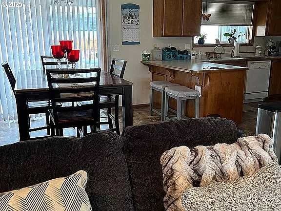 kitchen with sink, white dishwasher, and a breakfast bar