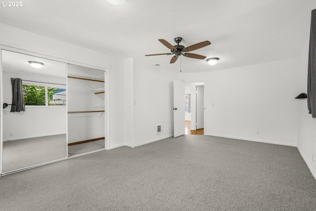 unfurnished bedroom with carpet flooring, baseboards, and a closet