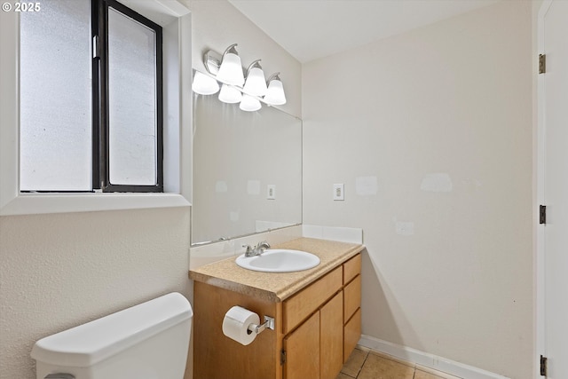 half bathroom with tile patterned flooring, toilet, vanity, and baseboards