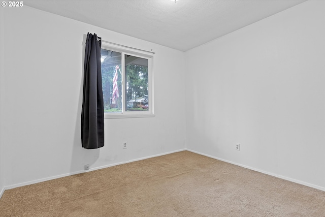 empty room with baseboards and carpet flooring