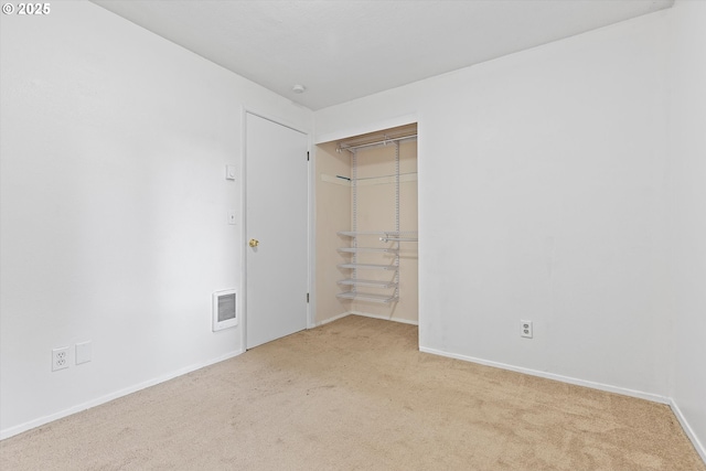 unfurnished bedroom featuring carpet, visible vents, a closet, and baseboards