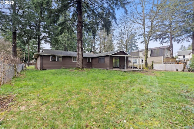 rear view of property featuring a yard, a fenced backyard, and a chimney