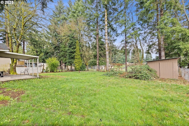 view of yard featuring an outbuilding, a fenced backyard, a shed, and a patio