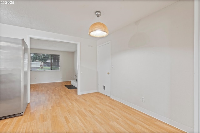 spare room with wood finished floors and baseboards