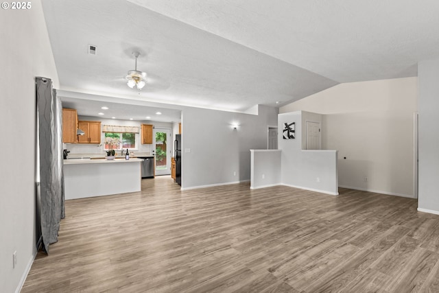 3191 Zinnia St, Eugene, OR 97404 - unfurnished living room with light wood-type flooring, ceiling fan, vaulted ceiling, and recessed lighting