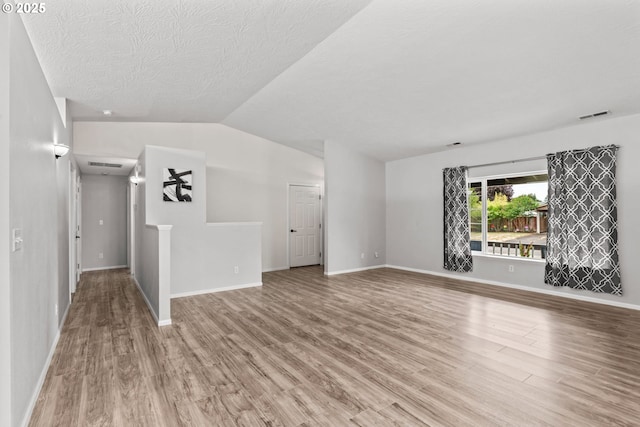 3191 Zinnia St, Eugene, OR 97404 - unfurnished living room with wood finished floors, vaulted ceiling, and a textured ceiling