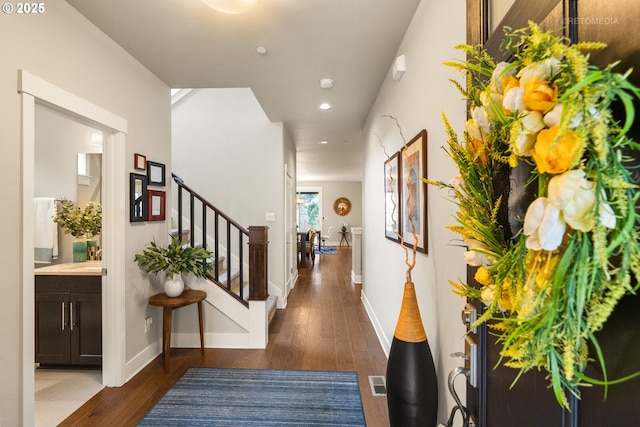 hall featuring visible vents, wood finished floors, recessed lighting, stairway, and baseboards