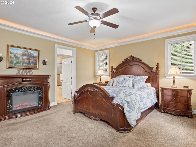 bedroom with multiple windows, a high end fireplace, light colored carpet, and ceiling fan