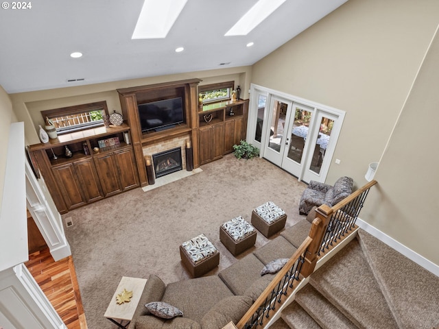 living room with carpet floors and vaulted ceiling with skylight