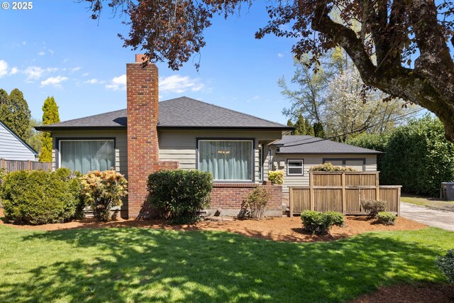 1013 NE Birchwood Dr, Hillsboro, OR 97124 - view of front of home with a chimney, a front lawn, a shingled roof, fence, and brick siding