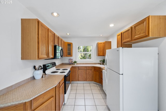 1013 NE Birchwood Dr, Hillsboro, OR 97124 - kitchen with recessed lighting, light countertops, freestanding refrigerator, black microwave, and electric range oven