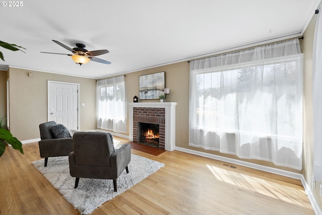 1013 NE Birchwood Dr, Hillsboro, OR 97124 - living room with visible vents, a brick fireplace, baseboards, and crown molding