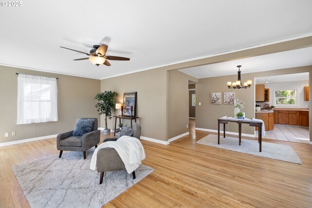 1013 NE Birchwood Dr, Hillsboro, OR 97124 - sitting room featuring ceiling fan with notable chandelier, baseboards, light wood-style floors, and ornamental molding