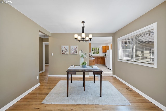 1013 NE Birchwood Dr, Hillsboro, OR 97124 - dining space featuring baseboards, a chandelier, visible vents, and light wood-style floors