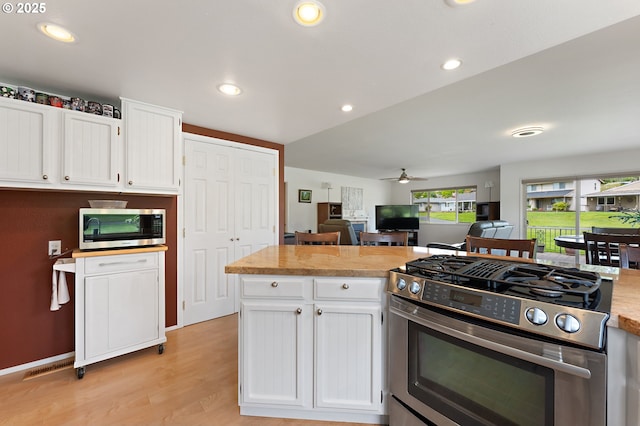 kitchen featuring white cabinets, light countertops, light wood-style flooring, stainless steel appliances, and a ceiling fan